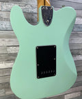 Back view of a Stratocaster guitar body in light green with a black control cavity cover