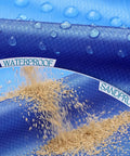 Close-up of Oversized Beach Blanket 78 By 81 Inches Go-To Picnic Mat showing waterproof and sandproof features with droplets and sand.