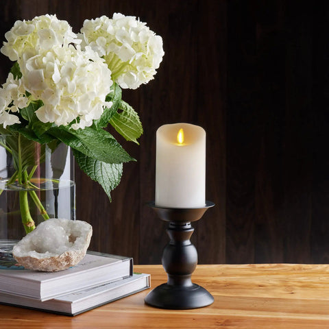 Flickering Flameless White Pillar Candle With Scalloped Edge 4.5 Inch on black holder with floral decor