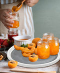 Non Skid Lazy Susan Turntable 360 Degree Kitchen Organizer with jam jars and apricots on a countertop