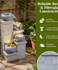 4-Tier Outdoor Water Fountain With Cascading Bowls, 23 Inch Tall, Warm LED Lights, And Submersible Pump in garden setting