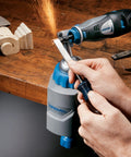 Person using 3 in 1 Multi Vise Attachment for Dremel Rotary Tool Stationary Vise as sparks fly during wood shaping in workshop