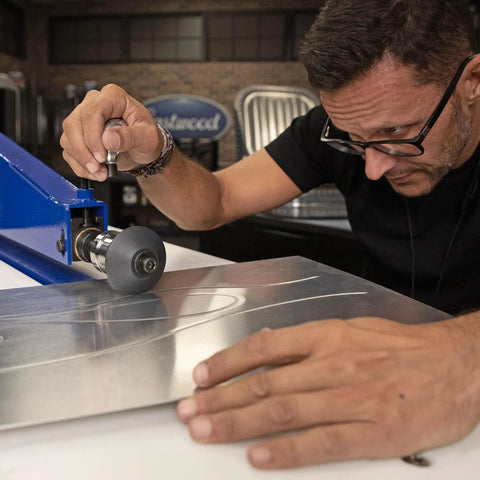 Killer Metal Fabrication Bead Roller Knobs For Motorized Units used on steel sheet; ergonomic grip enhances precise feeding.