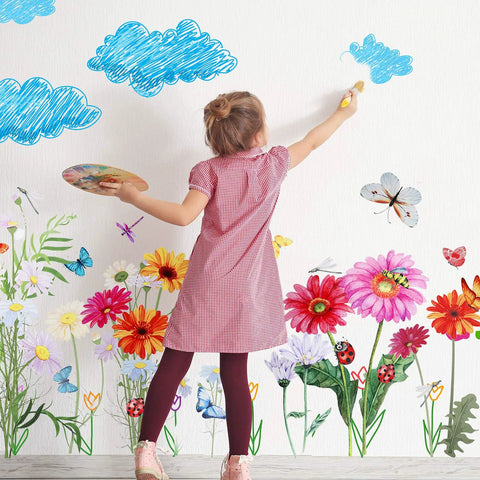 Girl painting a wall with 64 Pcs Flowers And Butterflies Wall Decals Peel And Stick Removable PVC Garden Murals for bedroom decor.