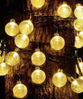 Two Pack Outdoor Solar String Lights With 60 LED Warm White Glow 40 Feet Of Durable String Lights wrapped around tree