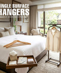 Room with Premium Wooden Coat Hangers 50 Pack for Closet Organization featuring coat hangers on bed and stand.