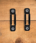 Heavy Duty Black Furniture Connectors And Hidden Screws For Dressers Bookshelves 50 Set on wooden background.