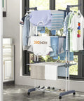 Top Shelf Oversized Four Tier Clothes Drying Rack With A Built Tough Foldable Frame Plus Side Wings For Hanging Laundry Towels Shoes And Quilts Roomy Air Drying Setup displaying clothes and towels indoors.