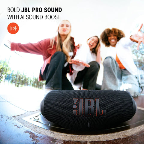 Close-up of Charge 6 Portable Waterproof Bluetooth Speaker With AI Sound Boost, people in background enjoying music outdoors.