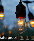 Close-up of lit 26 Pack S14 Light Bulbs for Outdoor String Lights with 11 Watt E26 Medium Base Clear Glass in rain