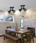 Dining room with wood table and two light black track lighting with pull chain, industrial adjustable ceiling light fixtures.