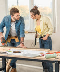 Two people working on a 60 Inch Adjustable Workbench With Rubber Wood Top Heavy Duty Workstation 2000 Lbs Load Capacity Hardwood Work Table.