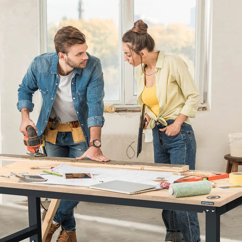 Two people working on a 60 Inch Adjustable Workbench With Rubber Wood Top Heavy Duty Workstation 2000 Lbs Load Capacity Hardwood Work Table.