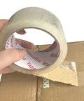 Hand holding heavy duty packing tape for shipping and moving, 1.88 inch wide by 65 yards per roll, sealing cardboard box