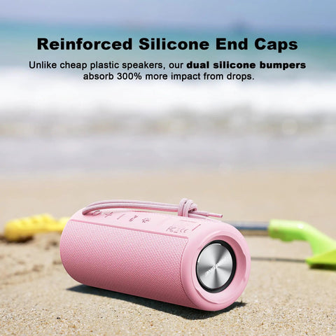 Pink outdoor portable Bluetooth boombox speaker waterproof shown on sandy beach with dual silicone end caps.