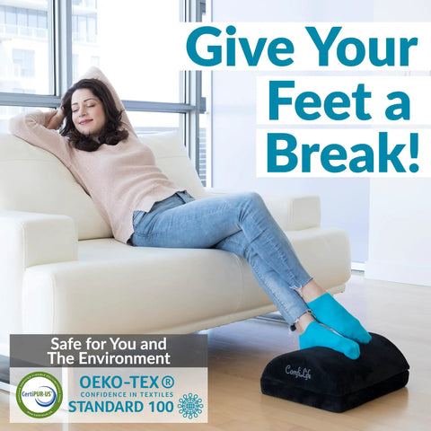 Woman relaxing on couch with feet on black under desk foot rest for pain relief and all day comfort, memory foam foot stool