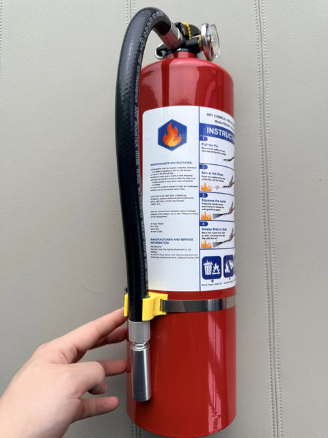 Four Pack Five Lb Abc Dry Chemical Fire Extinguisher Set Featuring No Fuss Quick Release Pin on display with user holding it.