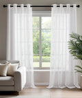 Oeko-Tex Certified Sheer Foil Print Curtains 2 Panels With Grommet Top Light Filtering Drapes For Living Room And Bedroom White And Silver 52W X 63L Inches Easy Care Adds Airy Privacy And Subtle Shine hanging in bright living room with sofa and plant.