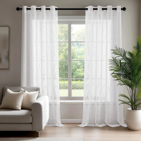 Oeko-Tex Certified Sheer Foil Print Curtains 2 Panels With Grommet Top Light Filtering Drapes For Living Room And Bedroom White And Silver 52W X 63L Inches Easy Care Adds Airy Privacy And Subtle Shine hanging in bright living room with sofa and plant.