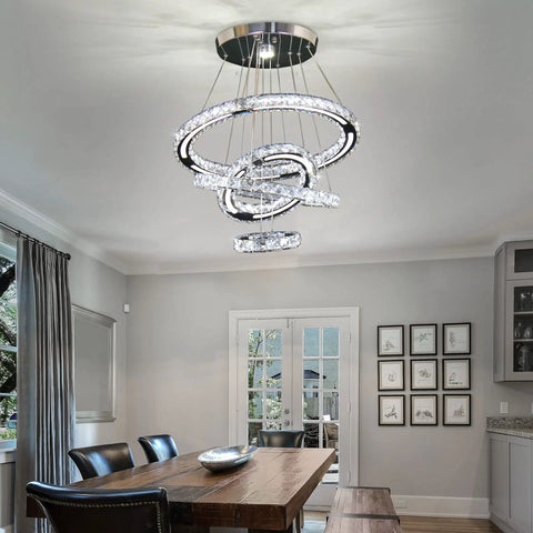 LED Crystal Chandelier With 4 Ring Design illuminating a dining room, featuring modern stainless steel and adjustable rings up to 47 inches.