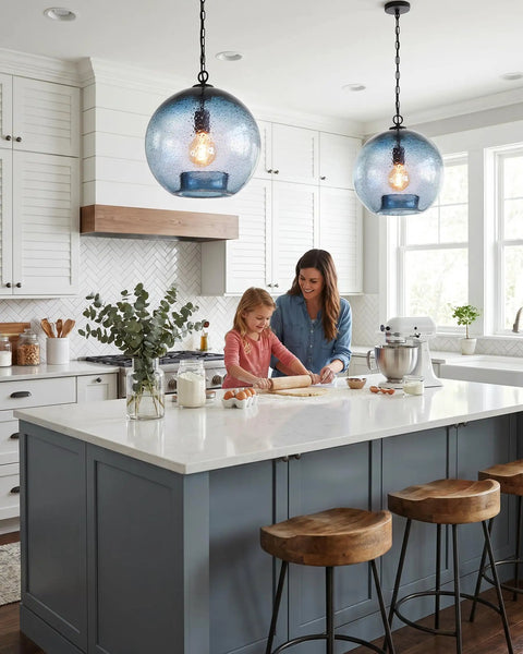 CASAMOTION Modern Farmhouse Blue Glass Globe Pendant Light 11" Dia hanging above a mother and daughter in a stylish kitchen.