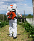Person using Beastly Heavy Duty Backpack Fogger Sprayer With 63cc 3HP Engine 20L Tank Long 39 Foot Spray Reach in garden.