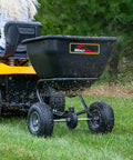 Deluxe Tow Behind Broadcast Spreader With Extended Easy Reach Handle And Weatherproof Cover, 175 lb capacity in use on lawn