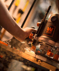 Person using Rock-Solid 15 Amp Variable Speed Plunge Router Kit With Carrying Case And Edge Guide on woodworking project.