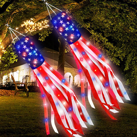 Patriotic 2 Pack 40 Inch American Flag Windsocks With Lights For Fourth Of July Memorial Day Independence Day Decor Red White Blue Stars And Stripes Hanging Windsocks glowing in a garden at night.