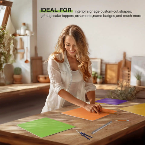 Woman creating with 7 Pack Rainbow Colored Plywood Sheets 12 By 12 By One Eighth Inch 3mm Thick Unfinished Wood For Laser Cutting And Engraving DIY Craft Kits For Ornaments Models Drawing And Wood Burning Projects in a workshop.
