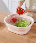 Person washing vegetables in Collapsible Pink Wash Basin Set Of 2 Foldable Portable Laundry Basins for home use