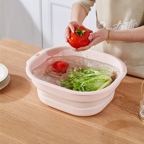 Person washing vegetables in Collapsible Pink Wash Basin Set Of 2 Foldable Portable Laundry Basins for home use