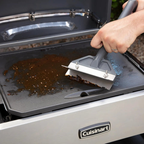 Beast Mode Heavy Duty Griddle Scraper With 6 Inch Stainless Steel Blade Ergonomic Handle And Splash Guard cleaning a grill
