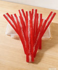 Twelve Inch Clear Acrylic Self Adhesive Piano Hinges Ten Pack, red strips displayed on a wooden surface, suitable for garage doors.