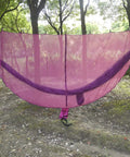 Premium Hammock Mosquito Net For Camping That Breathes Easy And Keeps Bugs Out tied between trees outdoors