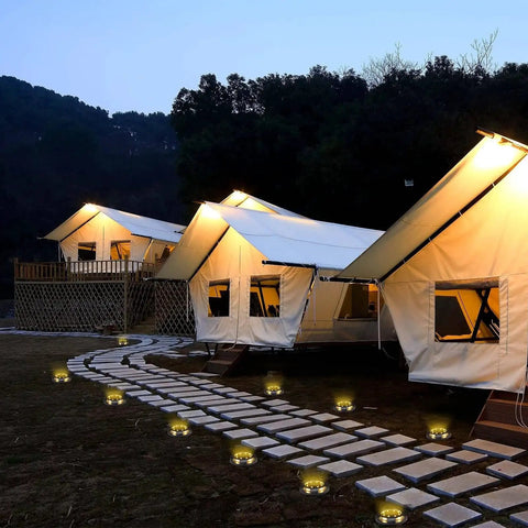 Solar Ground Lights Outdoor 12 Pack With 12 LED Disk Lights line pathway near tents at night
