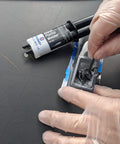 Black Plastic Weld Adhesive For Plastics Ceramics And Wood, Fast-Curing Structural Bond Up To 3500 Psi, Sets In Five Minutes, syringe with gloved hands