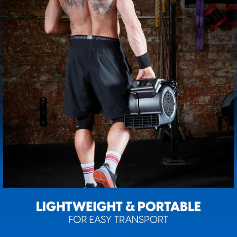 Person carrying High Power Floor Fan With Remote Control 32 MPH Air Mover for home gym use, showcasing portability.