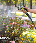 Relxitl garden hose with green and black 10-function spray nozzle, watering pink flowering shrubs.