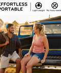 Two people sitting on a truck with a folded Hammock With Heavy Duty Steel Stand For Indoor And Outdoor Chill Sessions 600Lb Capacity.