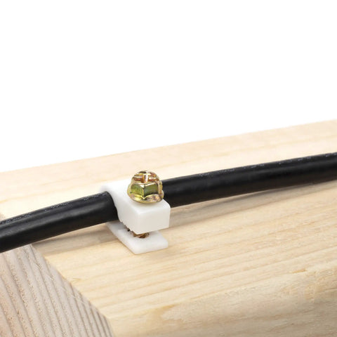 Ribbed Plastic Conical Wall Anchors And Cable Clips Set installed on wood with black cable secured by white clip.