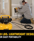 Man using Pancake Air Compressor 6 Gallon 165 PSI Portable Electric Air Pump for fastening at job site. Lightweight design.