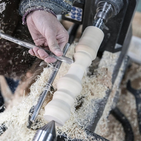 Rock Solid M2 High Speed Steel Spindle Gouge With Cryo Enhancement And Premium Beech Handle used in woodturning with shavings flying.
