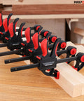 Heavy Duty Woodworking Bar Clamp Set, 12 Inch Two Pack And 6 Inch Two Pack, shown clamping wooden planks in workshop