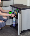 Person organizing supplies in Beast Of A Heavy Duty Freestanding Resin Garage Storage Cabinet With Adjustable Shelf In Gray, Real Space Saver For Laundry Room, Office Or Basement, 23.25 W X 13.75 D X 25.5 H, Sturdy Utility Organizer.