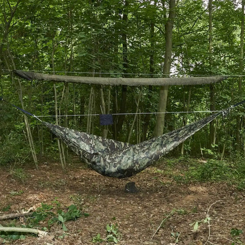 Snakeskin Tarp Sleeve 12ft Camping Rain Fly Storage Kit set up over hammock in forest, OD Green for hiking