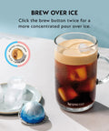 Vertuo Next Coffee and Espresso Maker By DeLonghi in creamy white creating an iced coffee with Nespresso capsule on table.