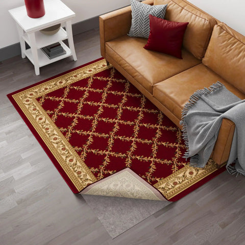 Living room with brown couch, red patterned rug, and 3 Ft By 11 Ft Rug Pad With Dual Surface Felt And Rubber Grip showing underneath.