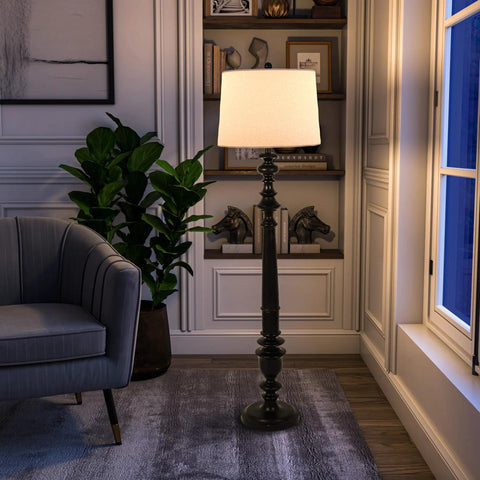 Benjamin Traditional Floor Lamp Satin Black Finish With Resin Construction next to a grey armchair in a cozy living room scene.