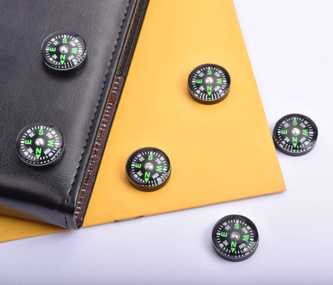 20 Pack Mini Pocket Oil Filled Compass 20mm Diameter Liquid Filled Grab And Go Navigation Tool shown on a notebook